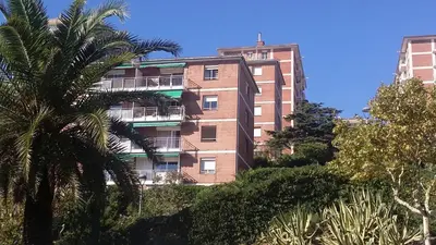 a tall brick building with a palm tree in front of it at Bianca Seaview & Beach Apartment in Montgat