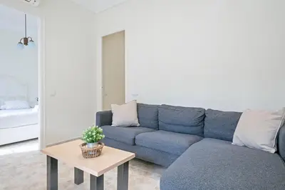 a living room with a blue couch and a table at Apartmento Industria in Barcelona