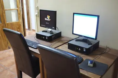 a desk with two monitors and a computer on it at Hostal Europa in Barcelona
