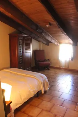 a bedroom with a bed and a chair in a room at Can Marc in Sant Esteve de Palautordera