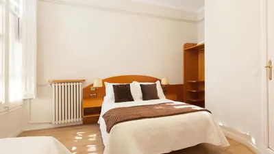a white bedroom with a bed and a radiator at Hostal Oliva in Barcelona