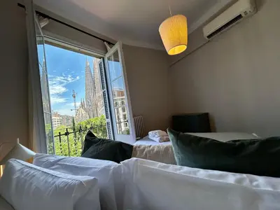 a bedroom with two beds and a large window at BarcelonaForRent Plaza Sagrada Familia in Barcelona