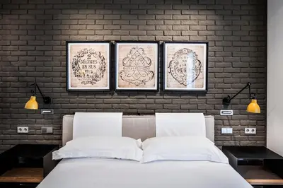 a bedroom with four framed pictures above a bed at Midtown Apartments in Barcelona