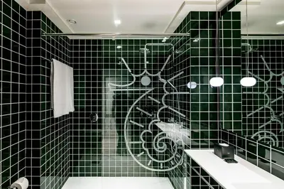 a green tiled bathroom with a shower with a bike on the wall at Midtown Apartments in Barcelona