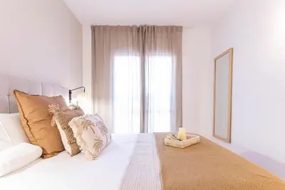 a white bedroom with a bed with a candle on it at Gran apartamento Sagrada Familia in Barcelona