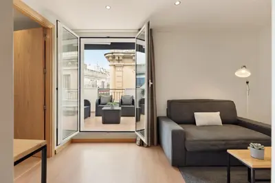 a living room with a couch and a view of a balcony at Sitges Group Soul in Sitges