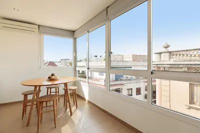 a room with a table and chairs and large windows at Sitges Group Soul in Sitges