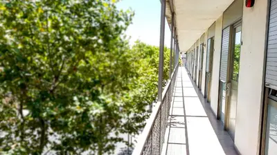 a balcony of a building with trees on the side at Apartaments Turístics Residencia Vila Nova in Vilanova i la Geltrú