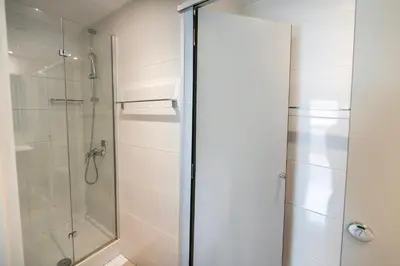 a shower stall with a glass door in a bathroom at Apartaments Turístics Residencia Vila Nova in Vilanova i la Geltrú