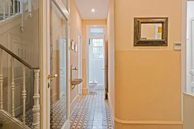 a hallway with a tile floor and a mirror at Villa Modernista in Barcelona