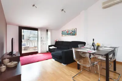 a living room with a black couch and a table at Matarolux 5 in Mataró