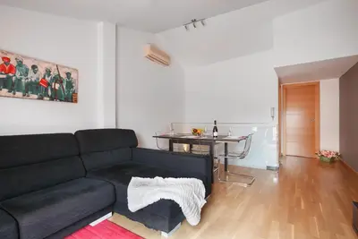 a living room with a black couch and a table at Matarolux 5 in Mataró
