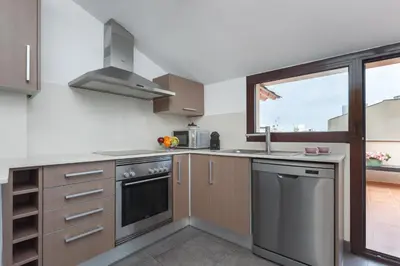 a kitchen with stainless steel appliances and a window at Matarolux 5 in Mataró