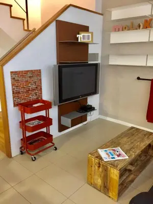 a living room with a tv and a staircase at Casas Apartamentos Gracia in Barcelona