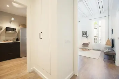 a kitchen with white walls and a large glass door at En Casa de Girona 17 in Barcelona