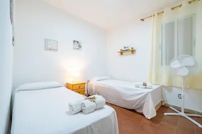 a bedroom with a bed with towels on it at HomeHolidaysRentals Sol in Pineda de Mar