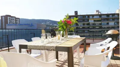 a table with a vase of flowers on a balcony at Ferran Pedralbes Penthouse in Barcelona