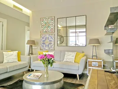 a living room with two couches and a table with flowers at Ferran Pedralbes Penthouse in Barcelona