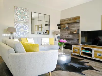 a living room with a white couch and a tv at Ferran Pedralbes Penthouse in Barcelona