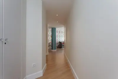 an empty hallway with white walls and wood floors at Passeig de Gracia Apartment in Barcelona