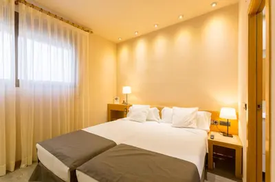 a hotel room with a bed and a window at Apartamentos DV in Barcelona