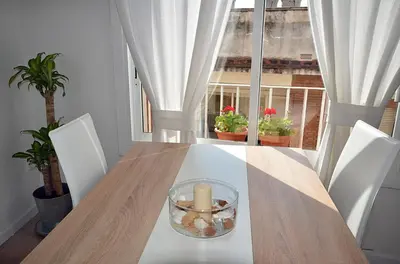 a dining room table with a candle and a window at Sunny Apartment Central Sitges in Sitges