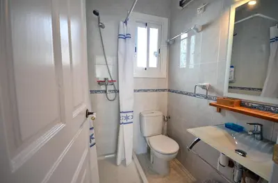a white bathroom with a toilet and a sink at Sunny Apartment Central Sitges in Sitges