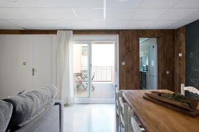 a dining room with a wooden table and a kitchen at Apartments Mo in Monistrol