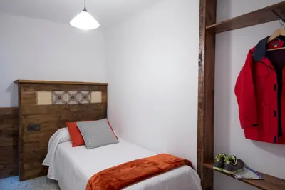 a bedroom with a bed and a red jacket on the wall at Apartments Mo in Monistrol