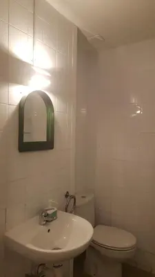 a bathroom with a sink and a toilet and a mirror at Central and Basic Universitat for YOUNG HOSTEL in Barcelona