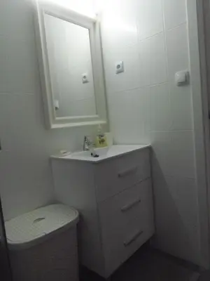 a bathroom with a sink and a toilet and a mirror at Apartment Aloha Sitges in Sitges