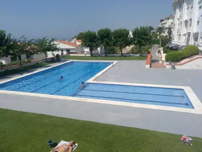 an empty swimming pool with two people in it at Apartment Aloha Sitges in Sitges