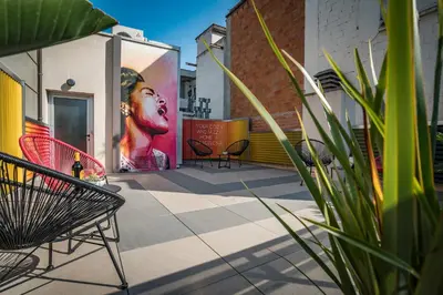 a patio with chairs and a painting on the side of a building at Habitat Apartments Hot Jazz in Barcelona