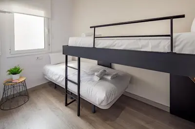a bedroom with two bunk beds and a table at Habitat Apartments Hot Jazz in Barcelona