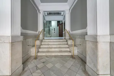 a staircase in a building with white walls and gold railings at Habitat Apartments Barcelona Classic in Barcelona