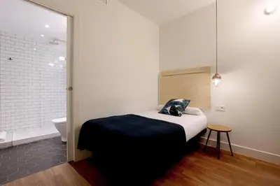 a bedroom with a bed and a bathroom with a toilet at Magatzem 128 in Barcelona