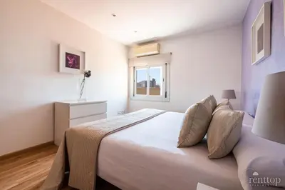 a bedroom with a large bed with a purple blanket on it at Rent Top Apartments Rambla Catalunya in Barcelona