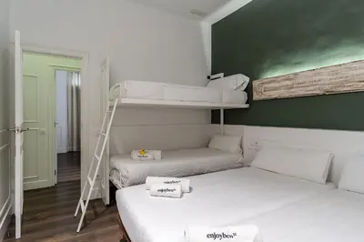a room with two bunk beds and a ladder at Enjoybcn Tallers Apartment in Barcelona