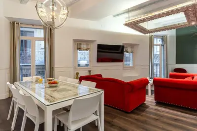 a living room with a table and a red couch at Enjoybcn Tallers Apartment in Barcelona