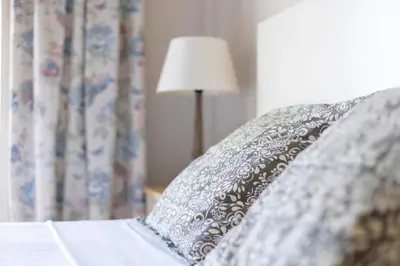 a bed with a pillow and a book and a lamp at Housalia Guell Gaudi in Barcelona