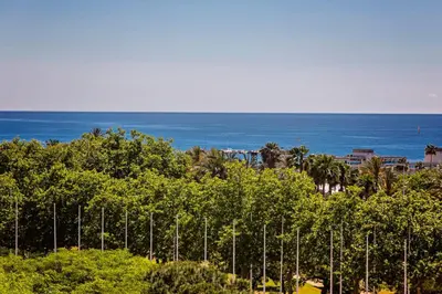 a row of trees with the ocean in the background at Sweett - Villa Olimpica Mediterranean in Barcelona