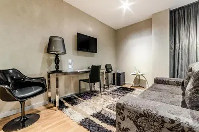 a living room with a couch and a desk at Eurostars Executive in Barbera del Valles