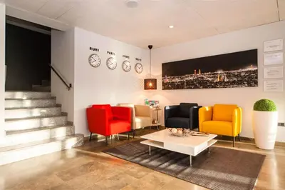 a lobby with colorful chairs and a table at HOTEL SANT PERE ll HSPII in Rubí