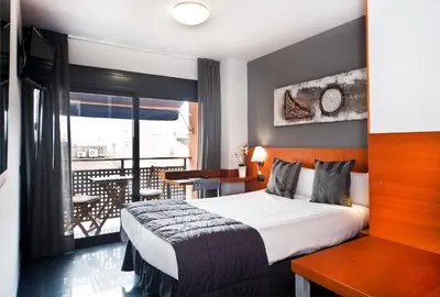 a hotel room with a bed and a balcony at HOTEL SANT PERE ll HSPII in Rubí