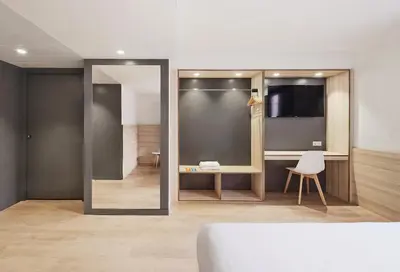 a room with a mirror and a table and a chair at Hostal Lami in Esplugues de Llobregat