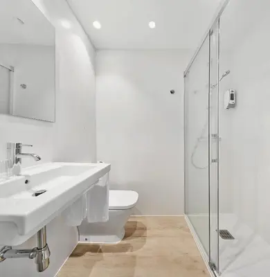 a white bathroom with a sink and a shower at Hostal Lami in Esplugues de Llobregat