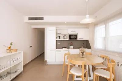 a kitchen and dining room with a table and chairs at Apartamentos Castellmar in Castelldefels
