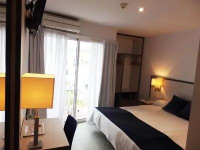 a hotel room with a bed and a large window at Parrots Sitges Hotel in Sitges