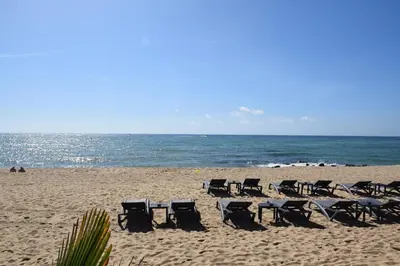 a group of chairs sitting on a beach at Apartamentos Les Barbes in Caldes d'Estrac
