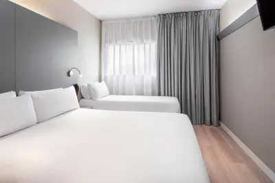 a hotel room with two beds and a window at B&B HOTEL Barcelona Mollet in Mollet del Vallès